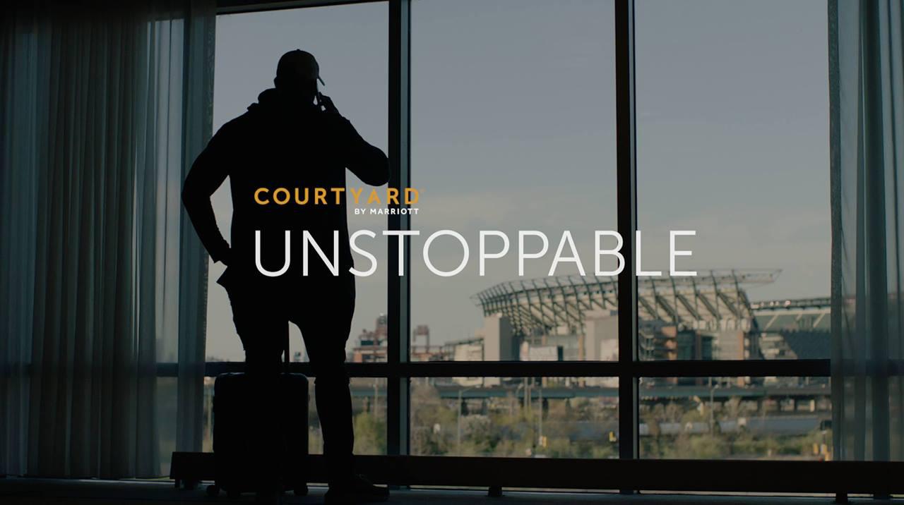 photo of a man in front of a window, with 'courtyard by marriott, unstoppable' text over the top